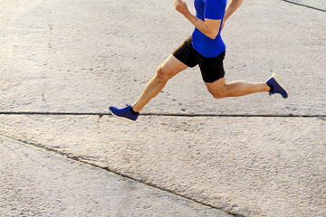 Wall Mural - male runner running on concrete road. top view