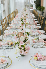 Wall Mural - Wedding decorations. Served wedding table with decorative fresh pink flowers and candles. Celebration details. Flower composition roses plates and candles in candlesticks