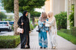 © oneinchpunch - Three women friends going out in Dubai. Girls wearing the united arab emirates traditional abaya