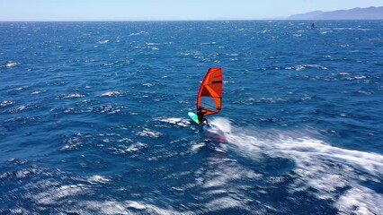 Wall Mural - Aerial drone video of wind surfer cruising in high speed in tropical wavy deep blue ocean bay