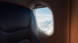 © alones - The interior of an airplane with a porthole flies in the sky with white clouds. Travel, business and transport, concept