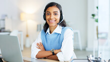 Portrait Of A Call Center Agent Using A Headset While Consulting For Customer Service And Sales Support. Confident Young Businesswoman Smiling While Operating A Helpdesk And Looking Confident