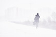 silhouette of a man walking in a snowstorm in the city the concept of a storm blizzard and bad weather.