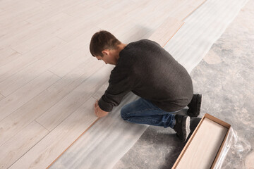 Poster - Professional worker installing new laminate flooring. Space for text