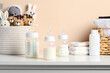 © New Africa - Feeding bottles with milk and other baby accessories on white table near beige wall