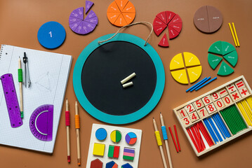 Wall Mural - Fractions, rulers, pencils, notepad on brown background. Set of supplies for mathematics and for school. Back to school, fun education concept	