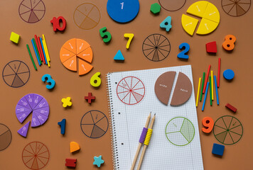 Wall Mural - Fractions, rulers, pencils, notepad on brown background. Set of supplies for mathematics and for school. Back to school, fun education concept	