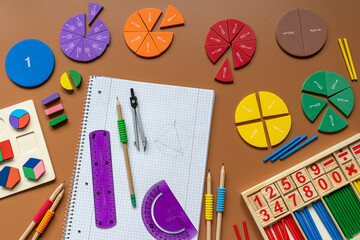 Wall Mural - Fractions, rulers, pencils, notepad on brown background. Set of supplies for mathematics and for school. Back to school, fun education concept