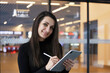 © areporter - beautiful business woman using tablet computer texting while walking in corporate office building, checking e-mail messages the internet, successful executive woman.