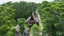 Chinese Village, Surrounded By Dense Crowns Of Trees. Well-preserved Houses With Gray Roofs, Fresh Green Crowns On Background. Endless Road, Originating From Noisy Capital, Reaching Quiet Settlement.