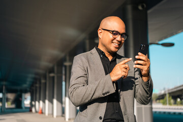 Senior manager business man in suit with cell phone at the buildings downtown. Confident man using smartphone looking towards their goals for success. Executive business man