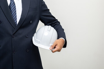 Wall Mural - Close up hand holding safety helmet Businessman manager owner real estate on isolated white background. Cooperation of architect designer. Engineer with hardhat checking at working construction site