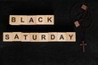 © sulit.photos - Black Saturday holy week concept. Wooden blocks typography with rosary flat lay in dark background.