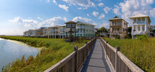 Wooden Boardwalk With Gazebo At The Front Of The Homes On The Beach At Destin Point, Destin, Florida. Views Of The Lake On The Left With Grass On The Shore Below The Wooden Path Heading To The Houses.