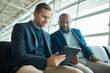 Tablet, businessman or people at airport meeting for flight update, travel news or schedule planning. Teamwork, lobby and technology of international corporate or entrepreneur black man with partner