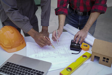 Smiling young architect or engineering builder in hard hat with tablet over group of builders at construction site, architect watching some a construction, business, building, industry, people concept