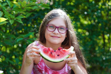  Close up portrait of young girl laughing, eating  and enjoying a watermelon.