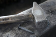 © Cavan Images - Hammer and nail on anvil at blacksmith shop