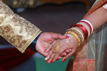 Sticker - Newly wed indian couple holding each other, close up photo of holding hands 