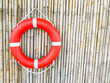 Lifebuoy hanging on bamboo wall background with space for text.