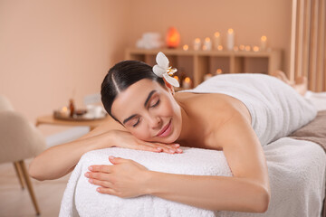 Young woman resting on massage couch in spa salon