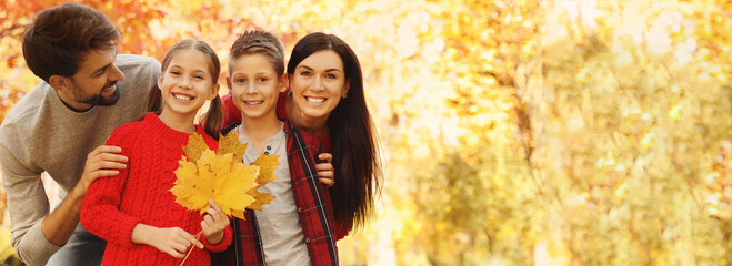 Autumn walk. Happy family with children spending time in park on sunny day, space for text. Banner design