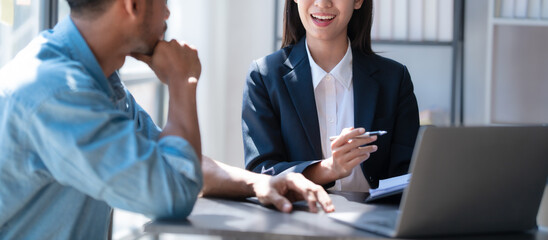 Wall Mural - Pointing laptop, Meeting and consulting agenda of indian asia mixed race business man and female china half thai ethnicity bookkeepers discussing balance sheet, stock market profit with yearly tax.