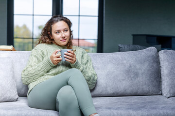 Wall Mural - Young woman drinking a cup of coffee