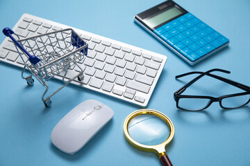 Canvas Print - Shopping cart with a computer keyboard and business objects.