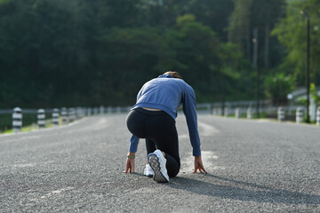 Athletic woman in starting position, ready to run outdoors. Make effort for victory, Fitness, sport and healthy lifestyle concept