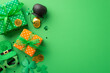 © ActionGP - St Patrick's Day concept. Top view photo of present boxes with ribbon bows pot with gold coins trefoils hat shaped party glasses and clover shaped confetti on isolated green background with copyspace