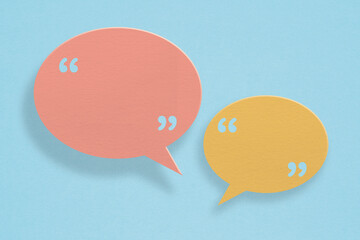 Conceptual image about communication and social media, customer feedback, yellow and pink speech bubble and quote sign grunge paper cut on grunge blue background