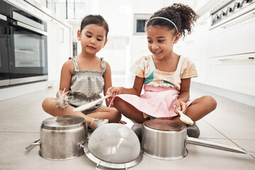 Girl children are playing house, pots as drums and happy, care free at family home and make believe with music fun. Noise, metal and kids on floor, play date together and fantasy with imagination