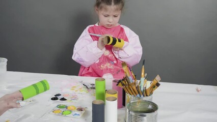 Wall Mural - Kids papercraft. Painting empty toilet paper rolls with acrylic paint to create paper bugs.