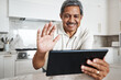 © Allistair F/peopleimages.com - Man, tablet and wave on video call in home for virtual communication, connection and social network. Happy mature guy with digital technology, hello and voip online with smile, happiness and web app