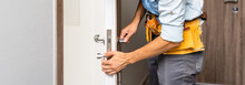 Two Worker Hands Of Carpenter At Lock Installation Into Wood Door