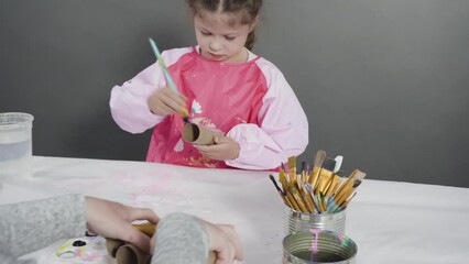 Wall Mural - Kids papercraft. Painting empty toilet paper rolls with acrylic paint to create paper bugs.