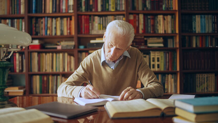 Wall Mural - Male scientist doing research in the library, reading books and writing down notes