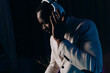 © Volodymyr - Neon light. portrait of a smiling man in headphones. Listening to music. a man in a white jacket and trousers.
