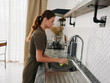 © SHOTPRIME STUDIO - Woman sad and unhappy hands without gloves washes dishes plate with bubble dishwashing sponge, household chores, no dishwasher, high water consumption. Stylish kitchen design, house cleaning