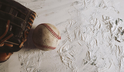 Canvas Print - Old used sports equipment with baseball ball and glove with white texture background.