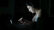 © Marco - Woman working at night in front of laptop. Person using computer studying in the dark and browsing internet online. Candid modern lifestyle with glowing screen