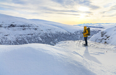 Snow shoe hiking on a beautiful sunny day at a mountain peak of Dovrefjell