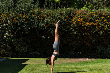 young and beautiful woman doing gymnastics in the garden of her house on a sunny day, yoga, diet, health