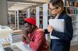 © DimaBerlin - Supportive teacher-student relationships. Young woman tutor comforting upset African guy college student while preparing him for university test in library. Private tutoring concept
