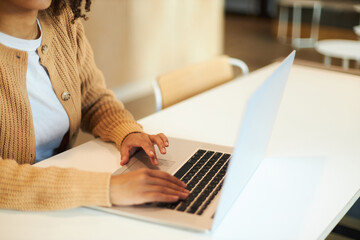 Closeup of copywriter hands typing on keyboard, using laptop working remotely in modern office, selective focus. Online business and education concept 