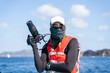 Marine biologist with scarf on face working on a boat