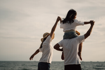 Wall Mural - Happy family spending time together at beach, Father give son piggyback on the beach, Father carrying his son with blue sky view, Family with holiday and travel concept