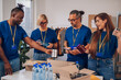 © Zamrznuti tonovi - Diverse volunteers working in a charity donation center and packing clothes and food