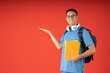 © Guillermo Spelucin - Young college man wearing glasses, smiling looking at the camera, with his hand extended to the right